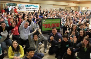 Members of the Dover Bay Eco Club, along with Staples Canada store manager Don MacKinnon (left, blue shirt), District manager Carlo Pellegrino (kneeling, striped shirt) and 250 other Dover Bay science students. Photo: Staples Canada